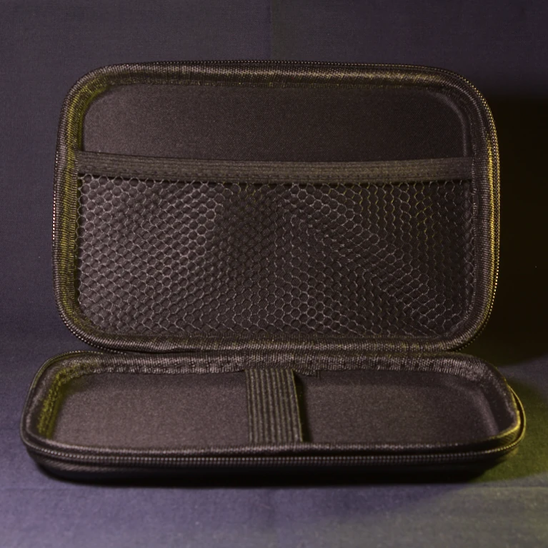 Interior of the official Anbernic RG DS carrying case shown open and empty, displaying the device compartment with elastic strap and an accessory pocket